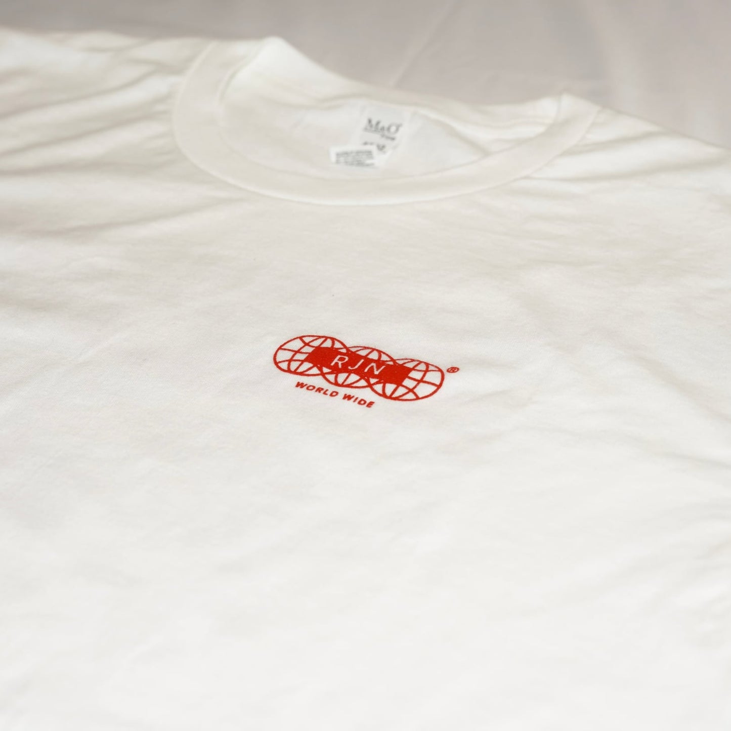 White t-shirt with a red logo on a light gray background